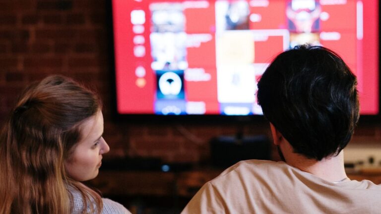 Worauf beim Kauf eines neuen Fernsehers achten Paar schaut gemeinsam Filme auf einem Smart-TV im Wohnzimmer