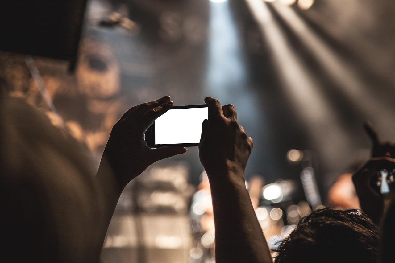 Hands holding a mobile phone with a bright blank screen