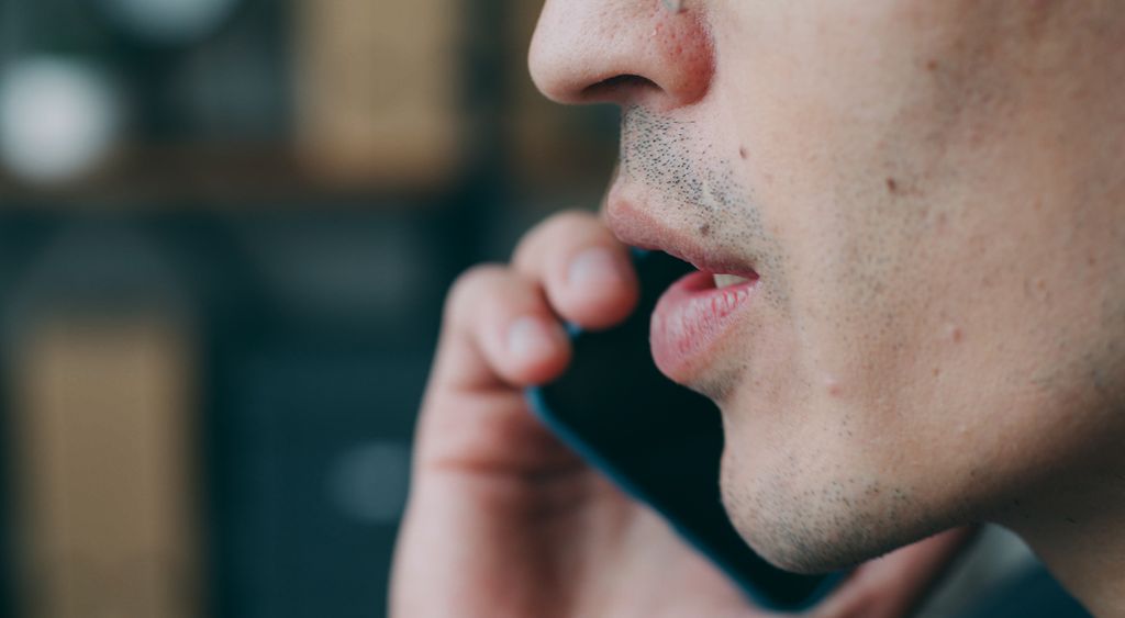 Close view of a person holding a phone to their ear during a call