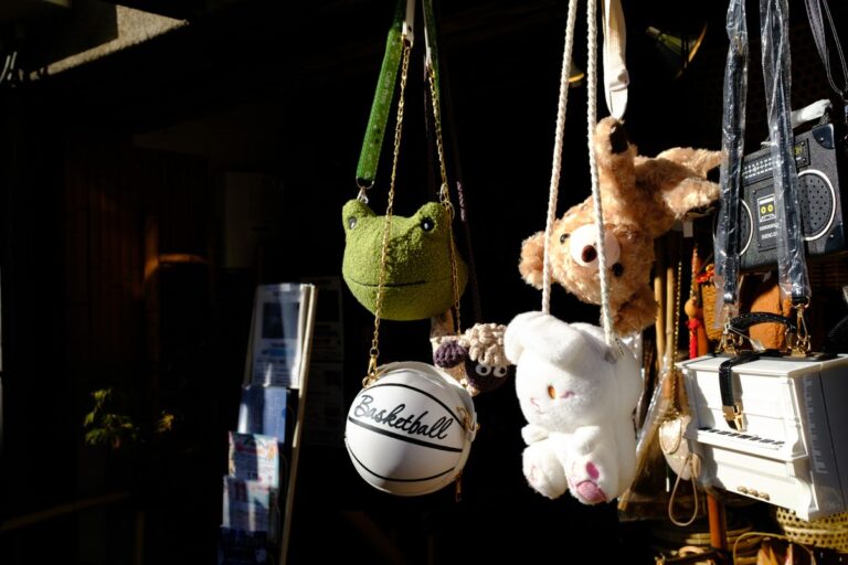 Plush toy bags and charms hanging on display in sunlight
