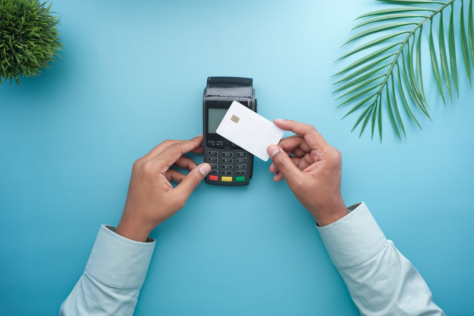 Plain payment card and a card machine held over a table