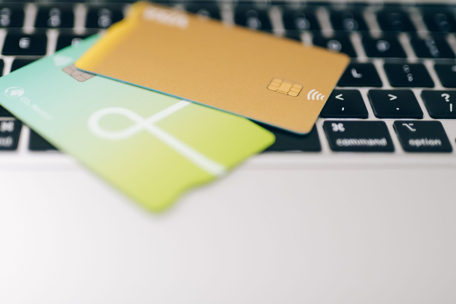Two plain payment cards resting on a laptop keyboard