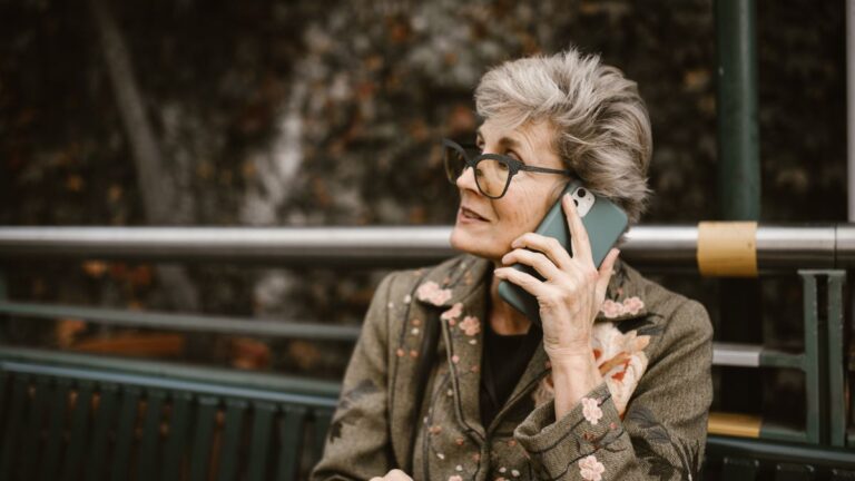 Older woman taking a call on a smartphone outdoors