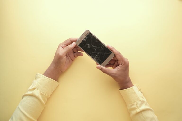 Accidental Damage Cover for Dropped Phones and Laptops on a Home Insurance Policy Hands holding a smartphone with a cracked screen