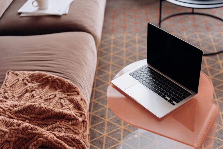 Broadband Switching Deals That Pay Off Your Old Contract Laptop on a side table in a cosy living room beside a sofa