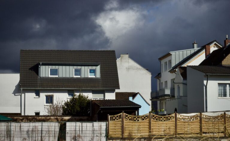 Buildings Insurance for Storm and Flood Damage to Your Home Dark storm clouds gathering over suburban houses