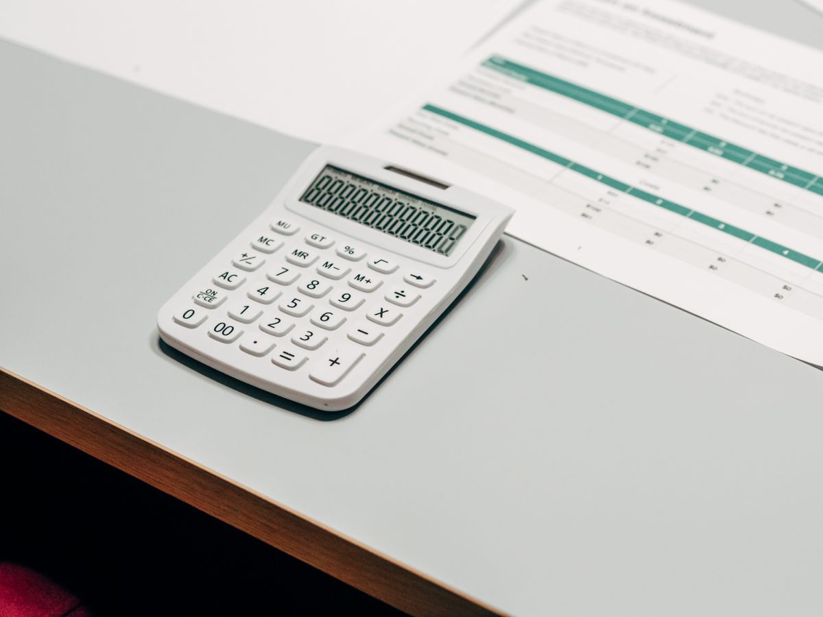 White calculator on a desk next to a printed statement