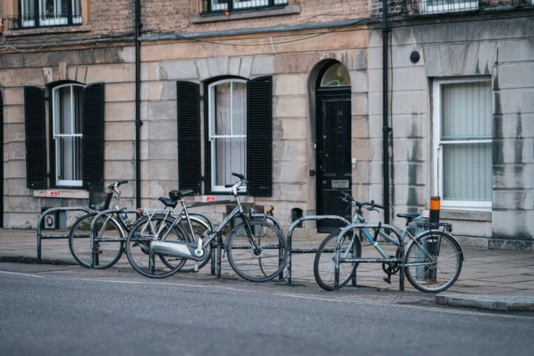 Bicycles locked to railings outside a row of period townhouses