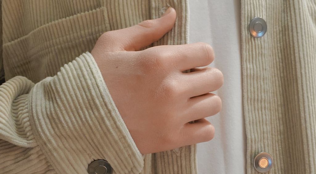 Close-up of a corduroy jacket with a snap button and chest pocket