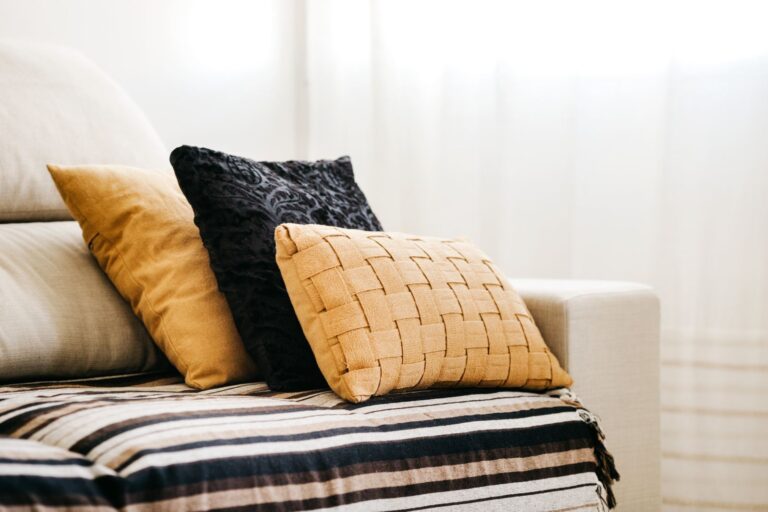 Mustard and black cushions arranged on a white sofa