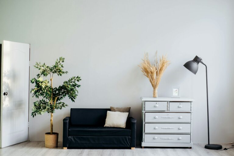 Best Lamps to Layer Light Across a Living Room A floor lamp standing beside a sofa in a bright living room