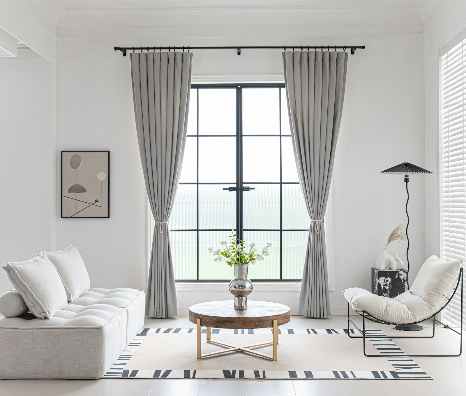 Full-length lined curtains tied back at a tall window in a bright living room