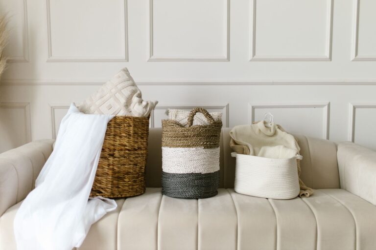 Storage That Hides the Clutter in a Small Flat Woven and fabric storage baskets on a bench with folded throws