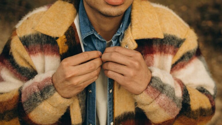 Layering Jackets to Get You Through Autumn A man fastening a wool overshirt worn over a denim shirt and tee