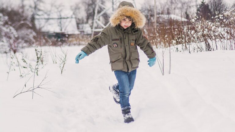 Garçon en parka à capuche marchant dans la neige
