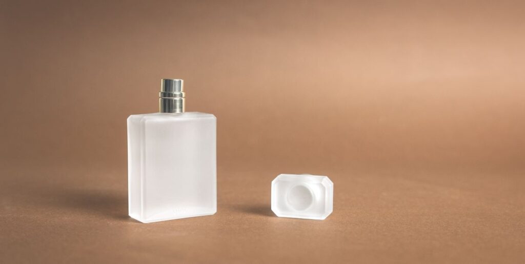 Eaux de Parfum Femme aux Signatures Florales et Orientales Frosted glass perfume bottle with its cap beside it