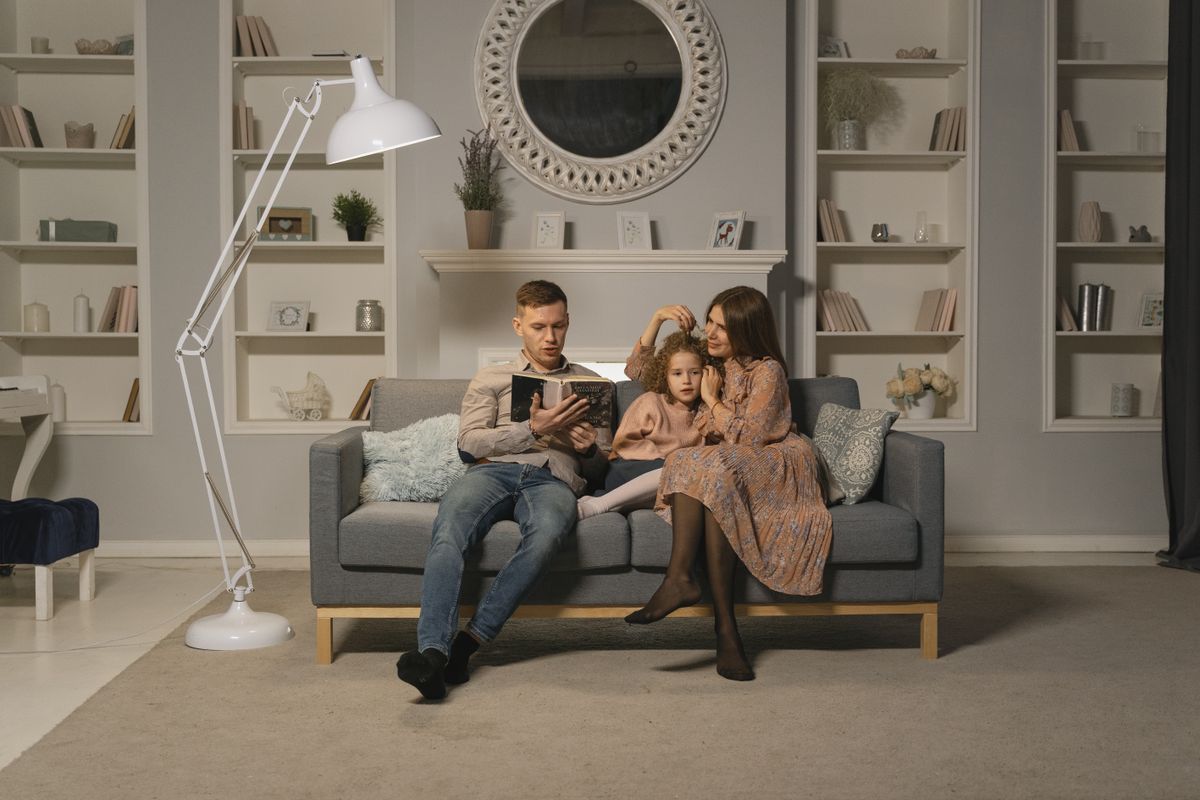 Family reading together on a sofa in a living room