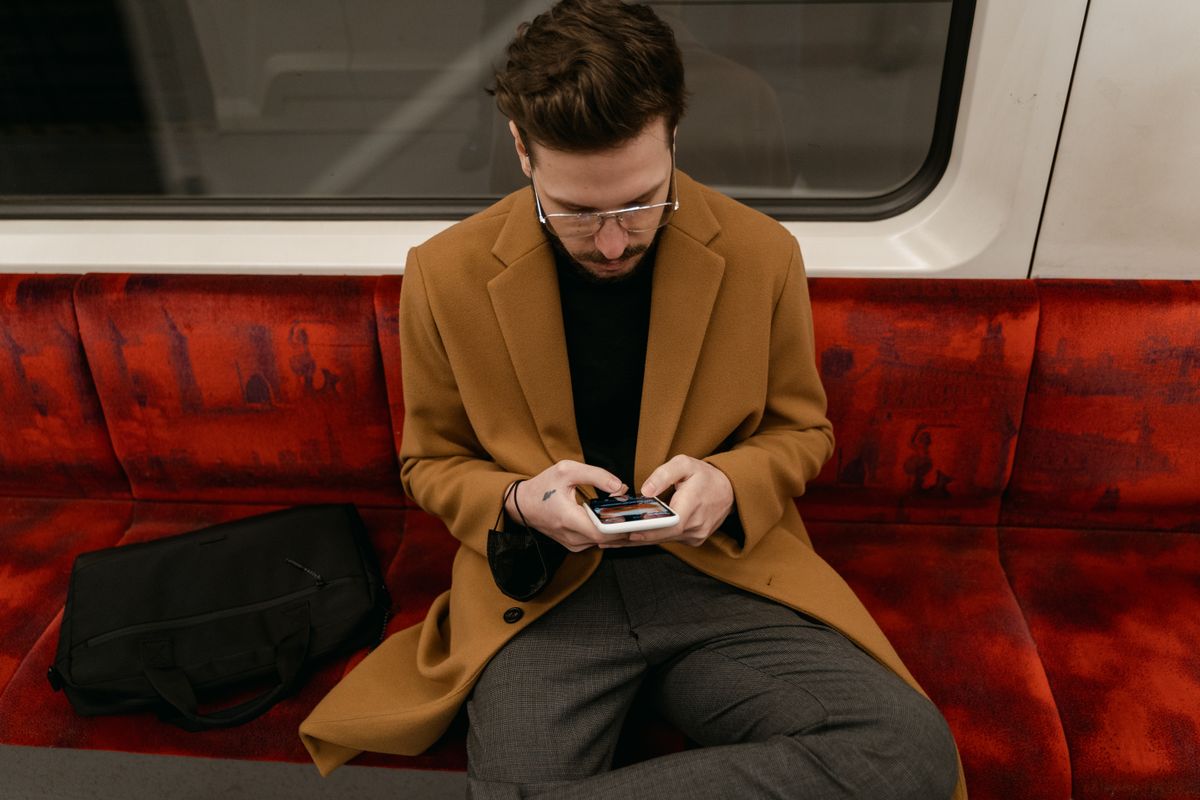 Voyageur lisant sur son téléphone dans un train