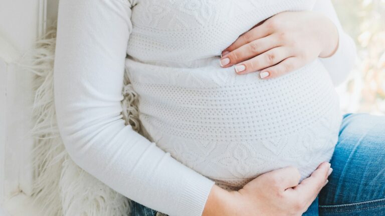 Femme enceinte en pull en maille blanc