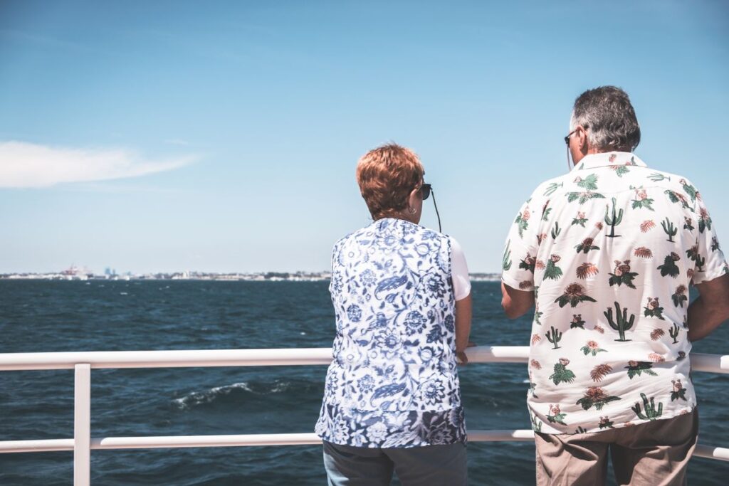 Retired couple looking out to sea from the deck of a ship
