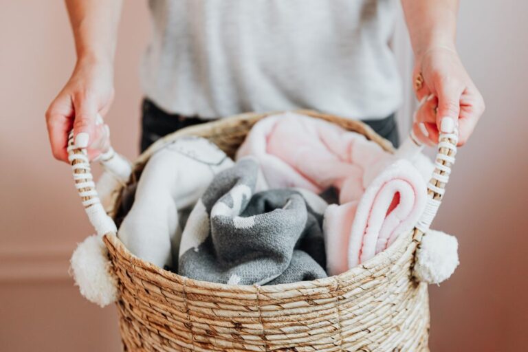 Nursery Basics for a Baby’s First Months A basket of folded baby clothes